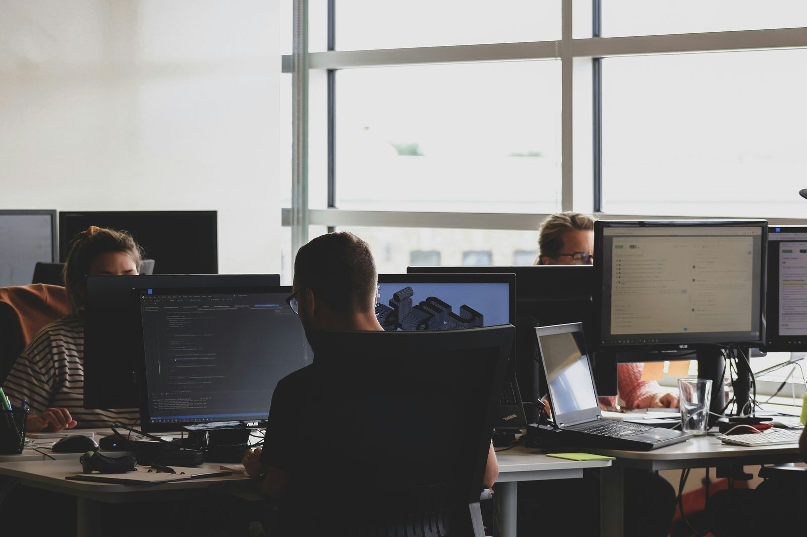 Team working together across multiple screens in an open office